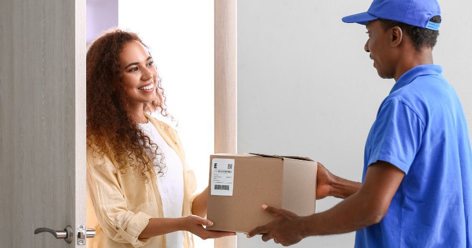 African-American Woman Receiving Parcel from Courier of Delivery Company