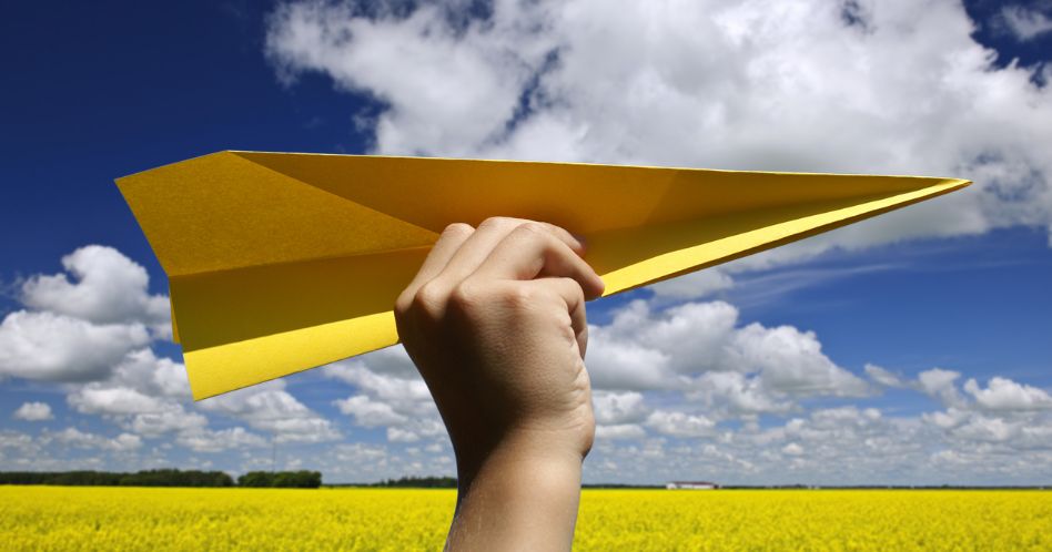 yellow paper airplane in canola field
